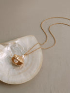 Gold scallop seashell locket necklace opening to reveal a freshwater pearl — Winding Moonlight