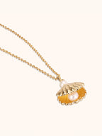 Gold scallop seashell locket necklace opening to reveal a freshwater pearl — Winding Moonlight